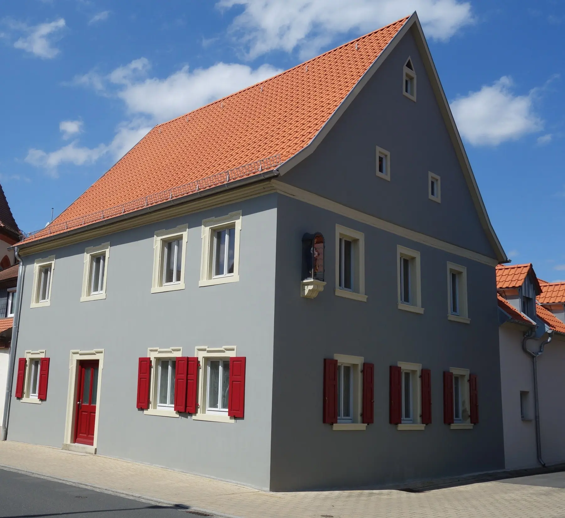 Fassadengestaltung mit roten Fensterläden